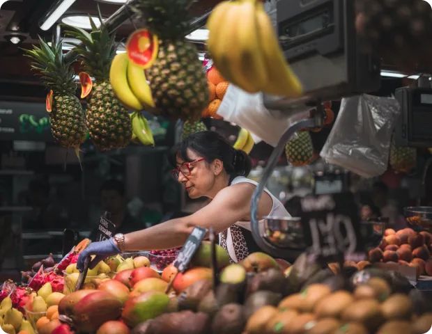 Puestera acomodando frutas en un mercado